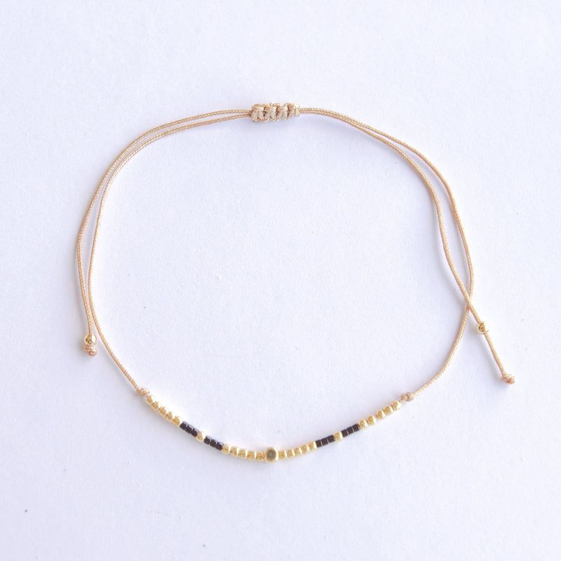 Add a pop of subtle color to your style with our Gleam Beads Adjustable Bracelets. Featuring different colors and gold beads on a silky cotton string, these adjustable bracelets are perfect for layering, with five colors available to create your unique combinations. Lightweight and comfortable, they’re ideal for everyday wear and special occasions alike. Don't forget to check our matchy anklets too!