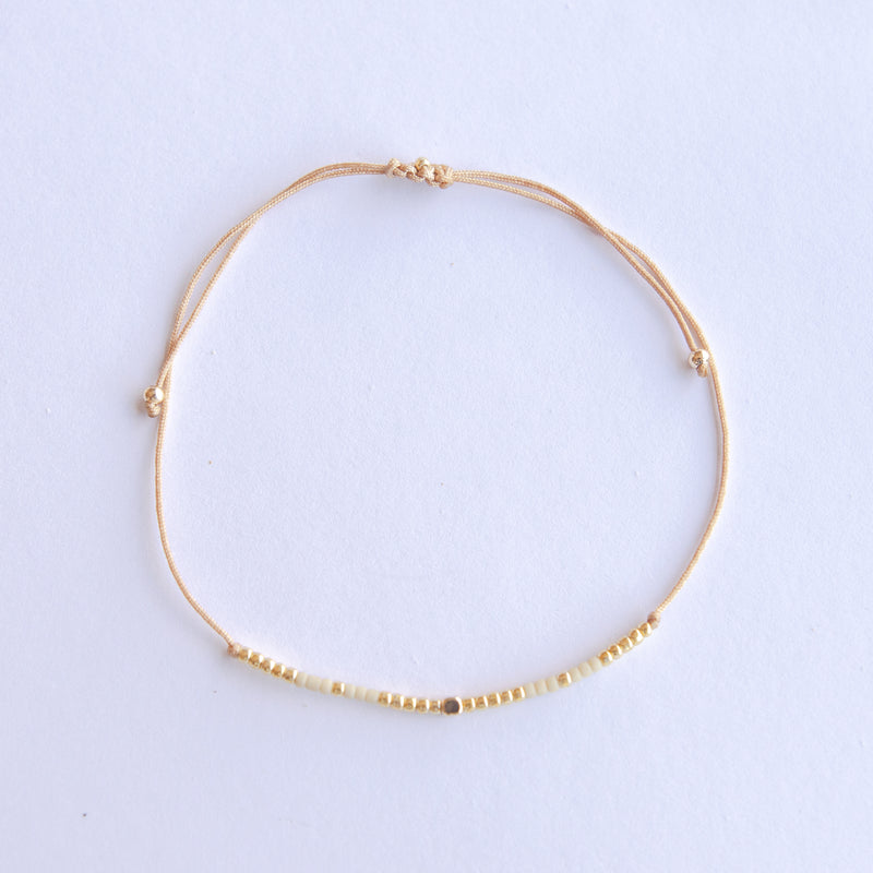 Add a pop of subtle color to your style with our Gleam Beads Adjustable Bracelets. Featuring different colors and gold beads on a silky cotton string, these adjustable bracelets are perfect for layering, with five colors available to create your unique combinations. Lightweight and comfortable, they’re ideal for everyday wear and special occasions alike. Don't forget to check our matchy anklets too!