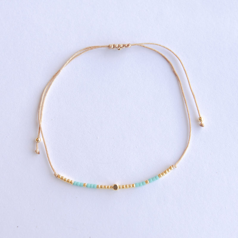 Add a pop of subtle color to your style with our Gleam Beads Adjustable Bracelets. Featuring different colors and gold beads on a silky cotton string, these adjustable bracelets are perfect for layering, with five colors available to create your unique combinations. Lightweight and comfortable, they’re ideal for everyday wear and special occasions alike. Don't forget to check our matchy anklets too!
