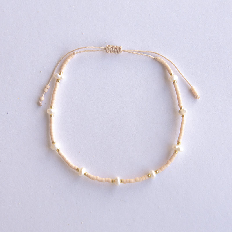 Elevate your style with our Petite Pearls Adjustable Bracelet. Combining modern fashion with timeless elegance, this adjustable bracelet features real freshwater pearls and silky string. 