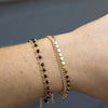 Gold bracelets with black beads and mini disc charms